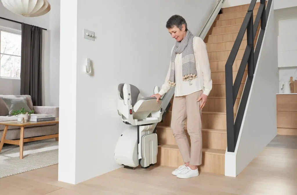 woman lowers the seat for straight stairlift rental