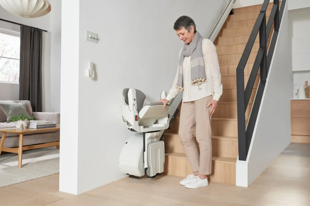 woman lowers the seat for straight stairlift rental