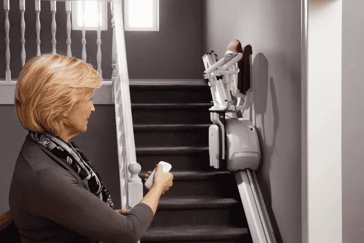 Woman using a remote to control Thyssen stairlifts