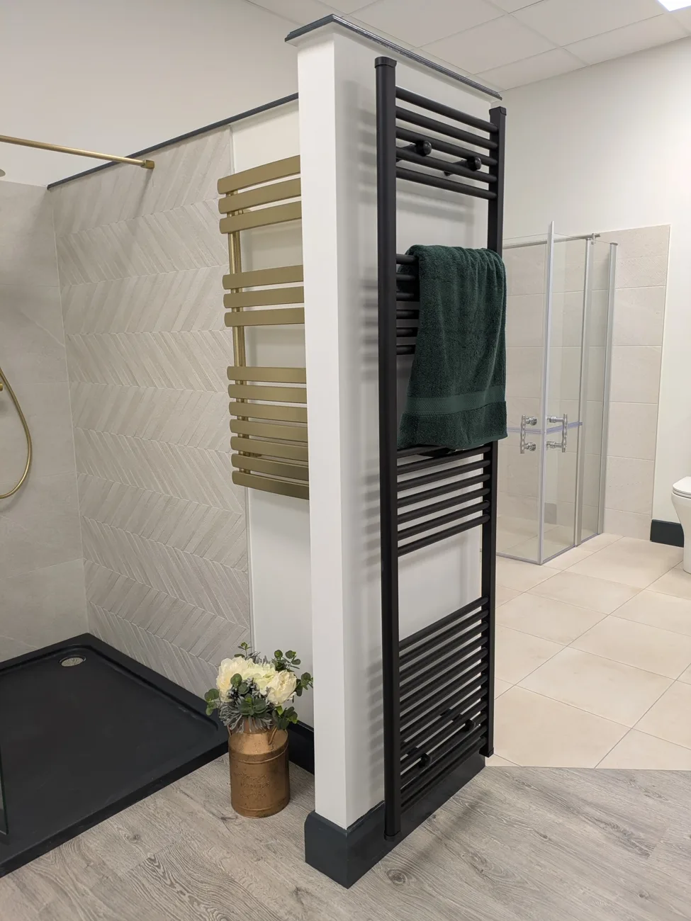 Matt black and brushed gold designer towel radiators on display