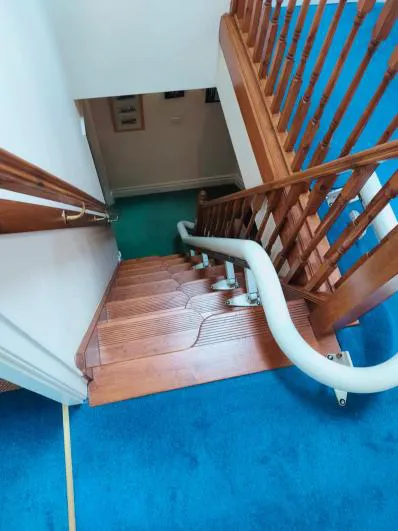 Flow X stairlift rail on a paddle staircase with a curved bottom turn