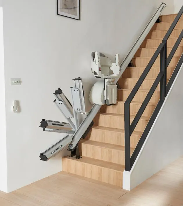 HomeGlide stairlift with hinged rail folding up at the foot of the stairs